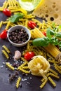 Ingredients for cooking Italian pasta - spaghetti, fusilli, fettuccine, basil, cherry tomato, garlic, pepper and cheese Royalty Free Stock Photo