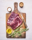 Ingredients for cooking meat raw steak with rosemary, pepper, spices and oil on a rustic wooden background Royalty Free Stock Photo