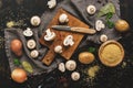 Ingredients for cooking mushroom soup on a dark rustic background, top view. Sliced mushrooms on a cutting board.Toned photo