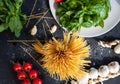 Ingredients for cooking pasta - raw spaghetti, basil, cherry tomatoes, garlic. Top view. Italian cuisine concept Royalty Free Stock Photo