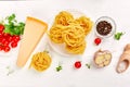 Ingredients for cooking pasta - tagliatelle, tomato, garlic, basil, parmesan cheese Royalty Free Stock Photo