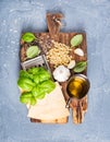 Ingredients for cooking Pesto sauce. Parmesan cheese, metal grater, fresh basil, olive oil, garlic and pine nuts on old Royalty Free Stock Photo