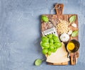 Ingredients for cooking Pesto sauce. Parmesan cheese, metal grater, fresh basil, olive oil, garlic and pine nuts on old Royalty Free Stock Photo