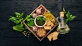 Ingredients for cooking Pesto sauce in a wooden box. Basil, parmesan cheese, olive oil, pine nuts, pepper, garlic. Royalty Free Stock Photo