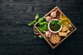 Ingredients for cooking Pesto sauce in a wooden box. Basil, parmesan cheese, olive oil, pine nuts, pepper, garlic. Royalty Free Stock Photo