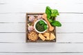 Ingredients for cooking Pesto sauce in a wooden box. Basil, parmesan cheese, olive oil, pine nuts, pepper, garlic. Royalty Free Stock Photo