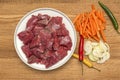 Ingredients for cooking pilaf on a wooden background. Onions, peppers, carrots, minced meat lie on a wooden cutting board. Cooking Royalty Free Stock Photo