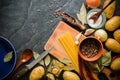 Ingredients for cooking: potatoes, salt, pepper, onion, garlic on a dark stone table. Royalty Free Stock Photo