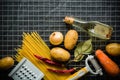 Ingredients for cooking: potatoes, salt, pepper, onion, garlic on a dark stone table. Metal grid. Royalty Free Stock Photo