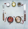 Ingredients for cooking, seasoning, oil, knife, fork, garlic, hot red pepper, lined frame on wooden rustic background top view clo Royalty Free Stock Photo