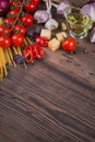 Ingredients for cooking spaghetti - raw pasta, tomato, olive oil, spices, herbs Royalty Free Stock Photo