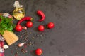 Ingredients for cooking spaghetti - raw spaghetti, cherry tomatoes, chili peppers, garlic, herbs, spices and olive oil on a black Royalty Free Stock Photo