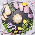 Ingredients for cooking turkey breast with pear, rice, herbs and vegetables are laid out on round cutting board Royalty Free Stock Photo