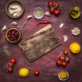 Ingredients for cooking vegetarian food tomatoes on a branch, lemon, olive oil, red hot pepper, herbs, cutting board , frame, with
