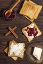 Ingredients for a delicious breakfast - toasted bread with butter and homemade raspberry jam on a wooden table. Top view Royalty Free Stock Photo