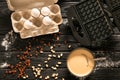 Ingredients and device for cooking Belgian waffles on dark wooden table