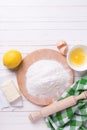 Ingredients for dough - flour, egg, butter, lemon on white wooden background. Royalty Free Stock Photo