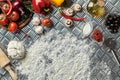 Ingredients and dough for making pizzas with an overhead view on freshly mixed mounds of pastry, a jar of olive oil and Royalty Free Stock Photo