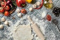 Ingredients and dough for making pizzas with an overhead view on freshly mixed mounds of pastry, a jar of olive oil and Royalty Free Stock Photo