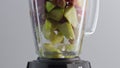 Ingredients fruit smoothie blending in mixer bowl super slow motion close up. Royalty Free Stock Photo