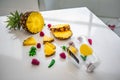 Ingredients for fruit smoothie on a white table, pineapple, raspberry, menthol Royalty Free Stock Photo