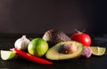 Ingredients for guacamole, avocado, lime, onion, garlic, tomato, pepper on dark wooden background, free space Royalty Free Stock Photo