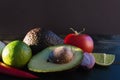 Ingredients for guacamole, avocado, lime, onion, garlic, tomato, pepper on dark wooden background, free space Royalty Free Stock Photo