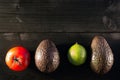 Ingredients for guacamole, avocado, lime, tomato, on dark wooden Royalty Free Stock Photo