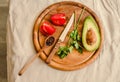 Ingredients for guacamole on a wooden board. Parsley, avocado, tomatoes, garlic, black pepper Royalty Free Stock Photo