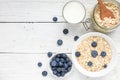 Ingredients for healthy breakfast - miilk, blueberries and oat muesli on white wooden table. top view Royalty Free Stock Photo