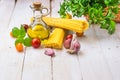 Ingredients for healthy Italian style meal with spaghetti, tomatoes, basil, garlic, parsley, olive oil on plank wood kitchen table Royalty Free Stock Photo