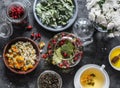 Ingredients for herbal tea - currant, mint, raspberry leaves, chamomile and calendula flowers, rose hips and teapot on a dark Royalty Free Stock Photo