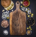 Ingredients for homemade burger with tuna, laid out around a cutting board on wooden rustic background top view border, place for Royalty Free Stock Photo