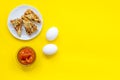 Ingredients for homemade cookies. Fresh cookies near jam, eggs on yellow background top view copy space Royalty Free Stock Photo