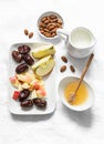 Ingredients for honey almonds apples protein smoothies on a light background, top view. Dates, almond milk, dates, honey, almonds