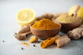 Ingredients for hot ayurvedic drink. Turmeric powder, curcuma root, cinnamon, ginger, lemon over grey background. Copy Royalty Free Stock Photo