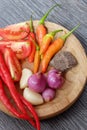 Ingredients of hot and spicy Sambal chili paste placed on wooden plate Royalty Free Stock Photo