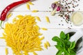 Penne Pasta, green basil, parmesan, sesame, garlic, chilli, eggs lie on a white tree table Royalty Free Stock Photo