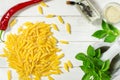 Penne Pasta, green basil, parmesan, sesame, garlic, chilli, eggs lie on a white tree table Royalty Free Stock Photo