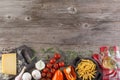 Ingredients for Italian dish. Parmesan cheese, pasta and fresh vegetables. On an old wooden background. Royalty Free Stock Photo