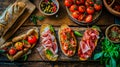 Ingredients for Italian snack, bruschetta, crostini or sandwich bar with Italian ham, sausage and antipasto on rustic wooden