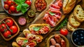 Ingredients for Italian snack, bruschetta, crostini or sandwich bar with Italian ham, sausage and antipasto on rustic wooden