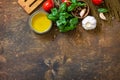Ingredients for italy cuisine. Spinach spaghetti, herbs, spices, olive oil and tomatoes on a rustic table. Top view flat lay. Royalty Free Stock Photo