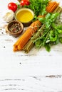 Ingredients for italy cuisine. Tomato and spinach spaghetti, herbs spices, olive oil and vegetables on a table. Royalty Free Stock Photo