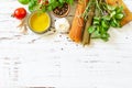 Ingredients for italy cuisine. Tomato and spinach spaghetti, herbs spices, olive oil and vegetables on a table. Royalty Free Stock Photo