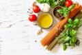 Ingredients for italy cuisine. Tomato and spinach spaghetti, herbs spices, olive oil and vegetables on a table. Royalty Free Stock Photo