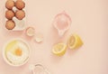 Ingredients and kitchen bake tools for cooking lemon cake or sweets - eggs, flour, hand juicer on a pastel punchy pink background.