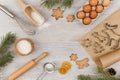 Ingredients and kitchen tools for cooking Christmas baking on light wood table top . Flour, eggs, rolling pin, cutters Royalty Free Stock Photo