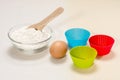 Ingredients for making biscuits: flour, egg, wooden spoon, silicone molds