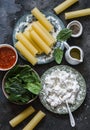 Ingredients for making cannelloni with spinach and ricotta on a dark background, top view Royalty Free Stock Photo